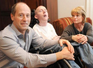 Jack Kelly, his son Brian, 24, and wife Jean at their Branford home. Brian suffers from Adrenoluekodystrophy (ALD). His parents are testifying in a public hearing at the Capitol tomorrow to try and get the screening for this disease covered by insurance. ALD is a disease that if caught early enough, many of the symptoms can be helped. Brian’s was caught at age 6, much too late. Tuesday, February 26, 2013. Photo by Peter Hvizdak / New Haven Register.